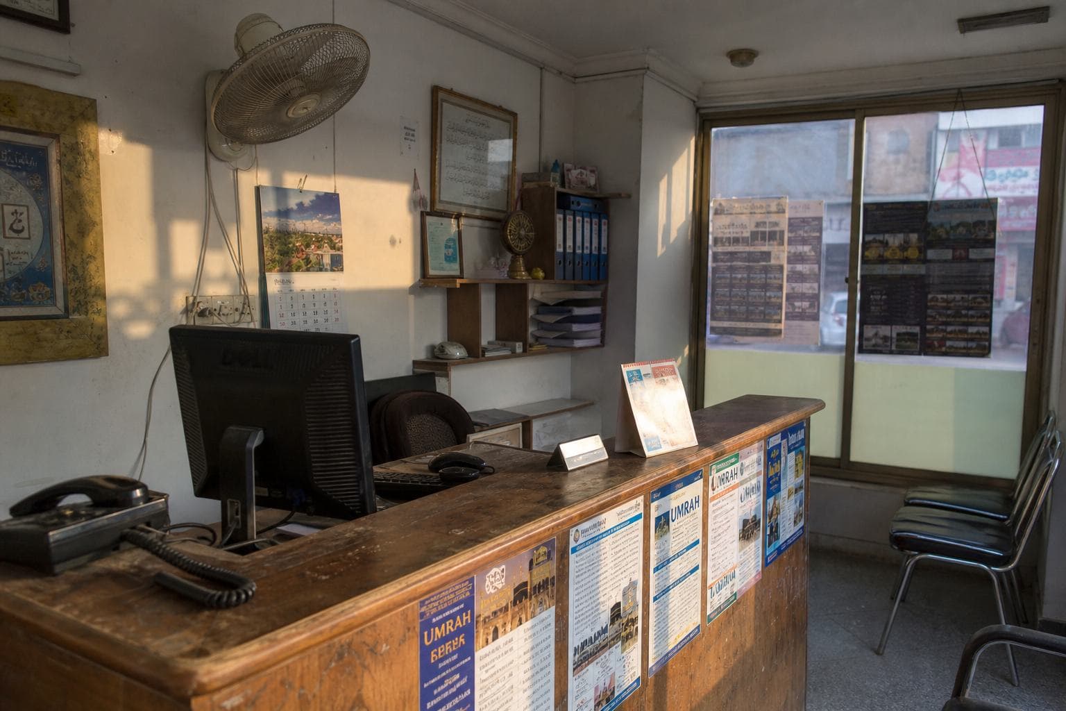 Travel-agency counter in Punjab with printed packages and a desktop.